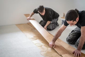 Fotobehang zwei Handwerker verlegen Parkettboden © Anselm