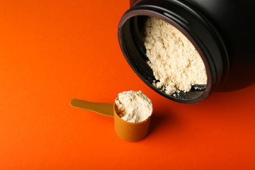 protein powder on orange background top view with copy space
