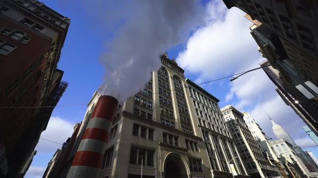 Steam rises and drifts among the rows of the Fifth Avenue buildings in the wintertime at Midtown Manhattan New York City NY USA on Dec. 27 2018.