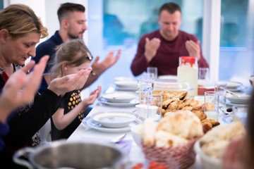 Eid Mubarak  Islamic family praying before halal Iftar dinner