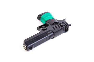 Black steel pistol with a handle wrapped in green electrical tape on a white isolated background