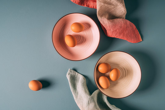 Overhead still life shot of farm fresh eggs on pastel plates with ombre napkins