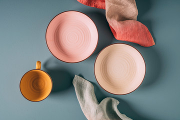 Still life of pastel colored ceramic dishes with ombre linens