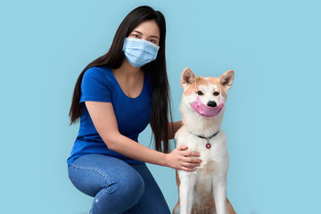 Young adult asian girl and her dog wearing in safety mask