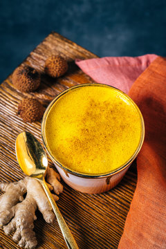 Golden milk latte in pink and gold cup with tumeric and ginger