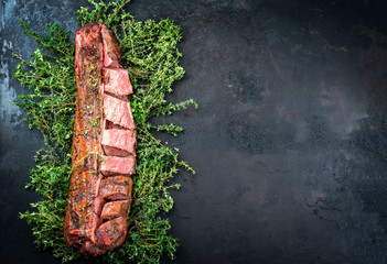 Barbecued dry aged venison tenderloin fillet steak and saddle natural with herbs offered as top...