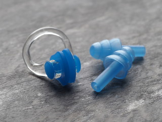 Nose clip and ear plugs for swimming pool on a gray background. Sport equipment. Set of earplugs...