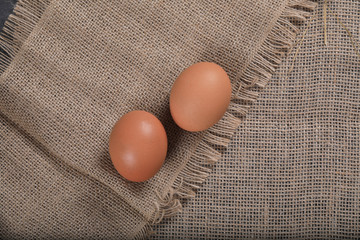 Healthy homemade eggs in hay on linen canvas background. Easter concept.