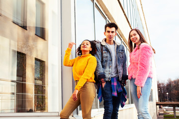 cute group of teenages at the building of university with books huggings, diversity nations real students lifestyle