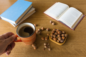 Relaxing reading books with coffee and hazelnuts.