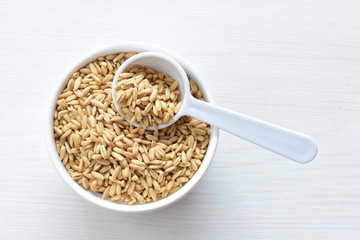 Oat grains accompanied by wheat ears in containers for display
