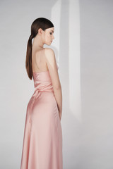 Fototapeta premium Beautiful woman pose in studio in pink classic dress