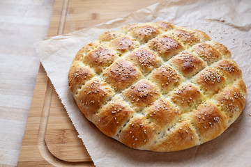Freshly baked flat bread in the style of turkish ramadan pide on a kitchen board
