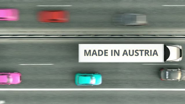 Aerial top down view of semi-trailer trucks with MADE IN AUSTRIA text driving along the highway. Venezuelan business related loopable 3D animation