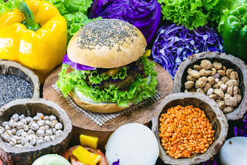 roasted vegan hamburger, made of vegetables and proteins. Healthy and vegetarian life concept. Colorful food, peppers, red cabbage, tomatoes, onions, chickpeas, soy, lettuce and lye