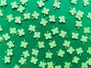 St. Patrick's Day background concept. Green clovers from paper on a green background. Copy space. Top view. 