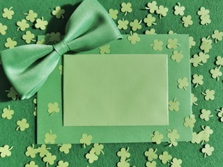 St. Patrick's Day background concept. Green clovers from paper and envelope on a green background....