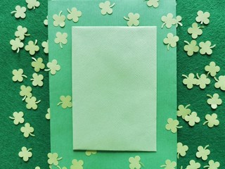 St. Patrick's Day background concept. Green clovers from paper and envelope on a green background. Copy space. Top view. 