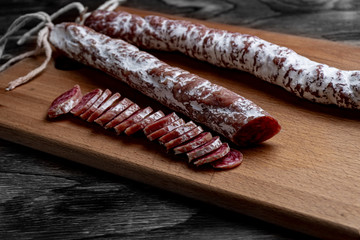 Fuet, a traditional Spanish sausage with rosemary. Slice sausages. Rosemary. Top view. Free space for your text.