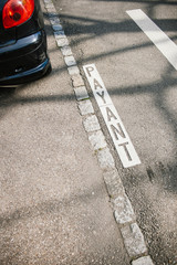 Fototapeta premium Payant przetłumaczone jako Płatny parking i część pojazdu w centralnej części francuskiego miastaa