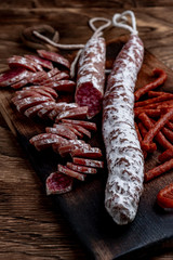 Fuet, a traditional Spanish sausage with rosemary. Slice sausages. Rosemary. Top view. Free space for your text.