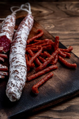 Fuet, a traditional Spanish sausage with rosemary. Slice sausages. Rosemary. Top view. Free space for your text.