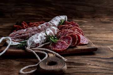 Fuet, a traditional Spanish sausage with rosemary. Slice sausages. Rosemary. Top view. Free space for your text.