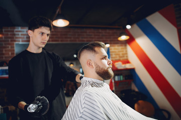 Man with a beard. Hairdresser with a client.