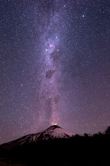 Thousands of stars in the sky with the Milky Way above the Villarrica Volcano in Chile with...