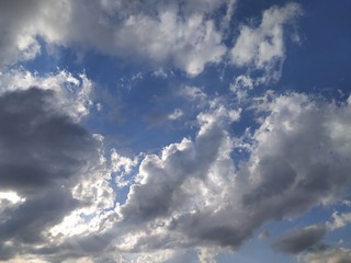 Obraz premium Blue sky with gray and white clouds at sunset, background, unstable changeable weather.