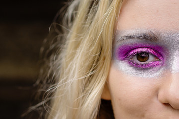 close up of womans face, she is wearing a bright mask style eye make up