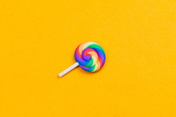 Lollipop close up. colorful candy on a yellow background. spiral caramel