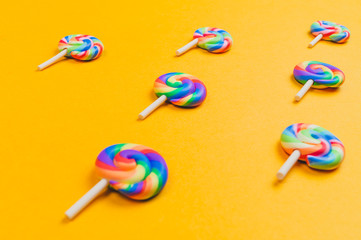 Lollipops are in a row. spiral candy pattern. lots of sweets on a yellow background. festive decoration