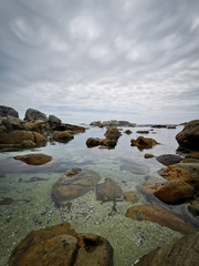 Beautiful sky over ocean water with rocks