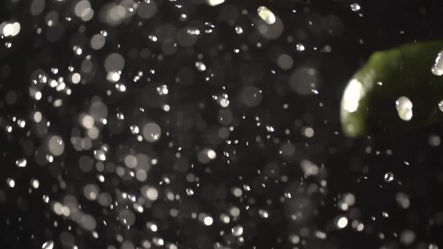 Avocado throw up with water splash droplets slow motion closeup on black background macro shot cooking video
