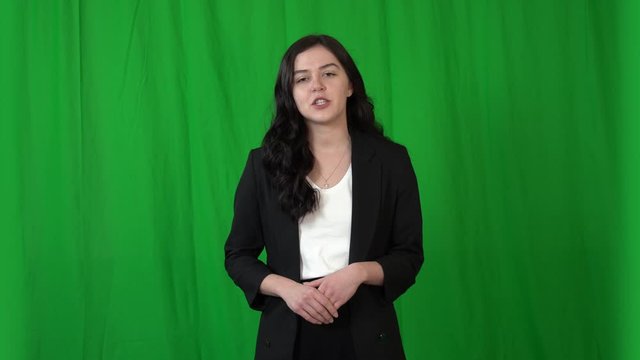 Beautiful brunette girl talking to the camera. Background - green screen for keying.  