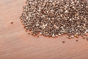 Heap of chia seeds on a wooden table.
