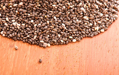 Heap of chia seeds on a wooden table.
