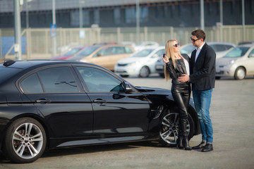 Naklejka na ściany i meble Happy young couple chooses and buying a new car for the family