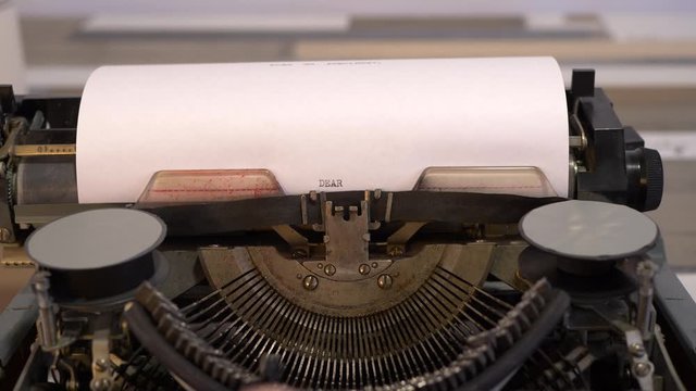 close-up typing a text DEAR SANTA CLAUS, old vintage typewriter with a sheet of paper 