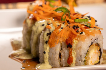 Sushi con camarón empanizado dentro y salmón con zanahoria rallada 