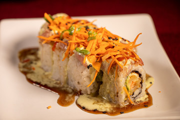 Sushi con camarón empanizado dentro y salmón con zanahoria rallada 