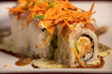 Sushi con camarón empanizado dentro y salmón con zanahoria rallada 
