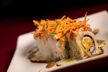 Sushi con camarón empanizado dentro y salmón con zanahoria rallada 