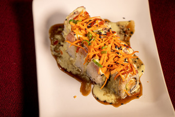 Sushi con camarón empanizado dentro y salmón con zanahoria rallada 