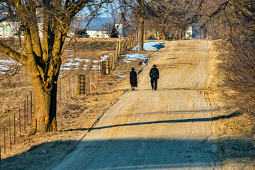 Amish Couple Walking to Church on Rural Road