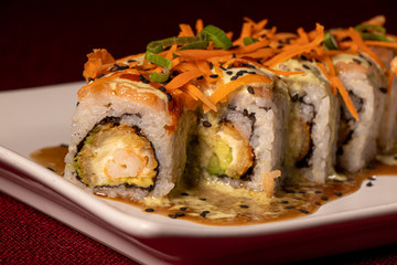 Sushi con camarón empanizado dentro y salmón con zanahoria rallada 