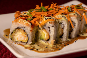 Sushi con camarón empanizado dentro y salmón con zanahoria rallada 