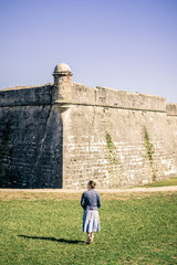 Girl in Denim Walking Towards Wall of Old Stone Fort in St Augustine