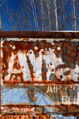 Flaking paint on an rusting abandoned Air Conditioning service truck in a forest